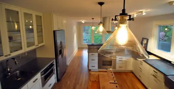 Residential electrician installing modern indoor light fixture in a home in Mountain View, CA