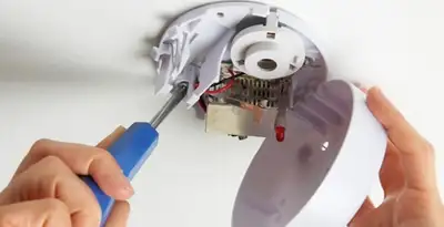 Certified technician wiring smoke detector during installation in Mountain View, CA